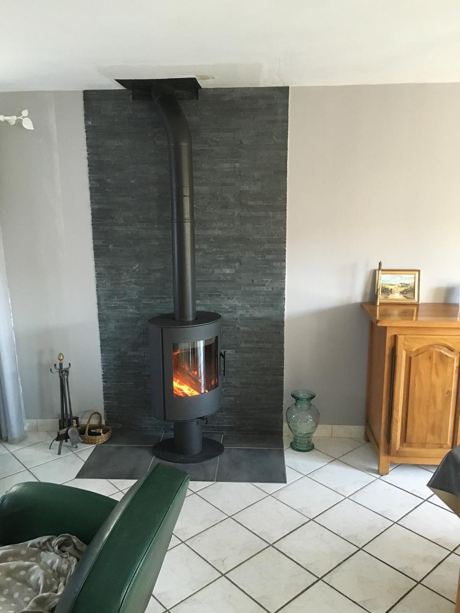 - Installation d'un poêle à bois ROMOTOP Evora T, finition acier, appareil flexible à 360°, solution idéale pour chauffer toute la pièce.